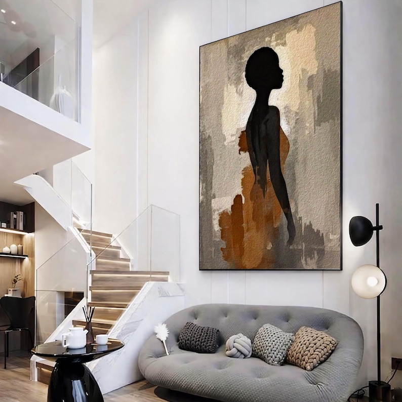 K&ouml;nnte beinhalten: Ein gro&szlig;es rechteckiges Wandbild mit der schwarzen Silhouette einer Person vor einem strukturierten Hintergrund aus beigen, grauen und rostorangen Pinselstrichen. Das Kunstwerk ist vertikal ausgerichtet und hat einen d&uuml;nnen schwarzen Rahmen.