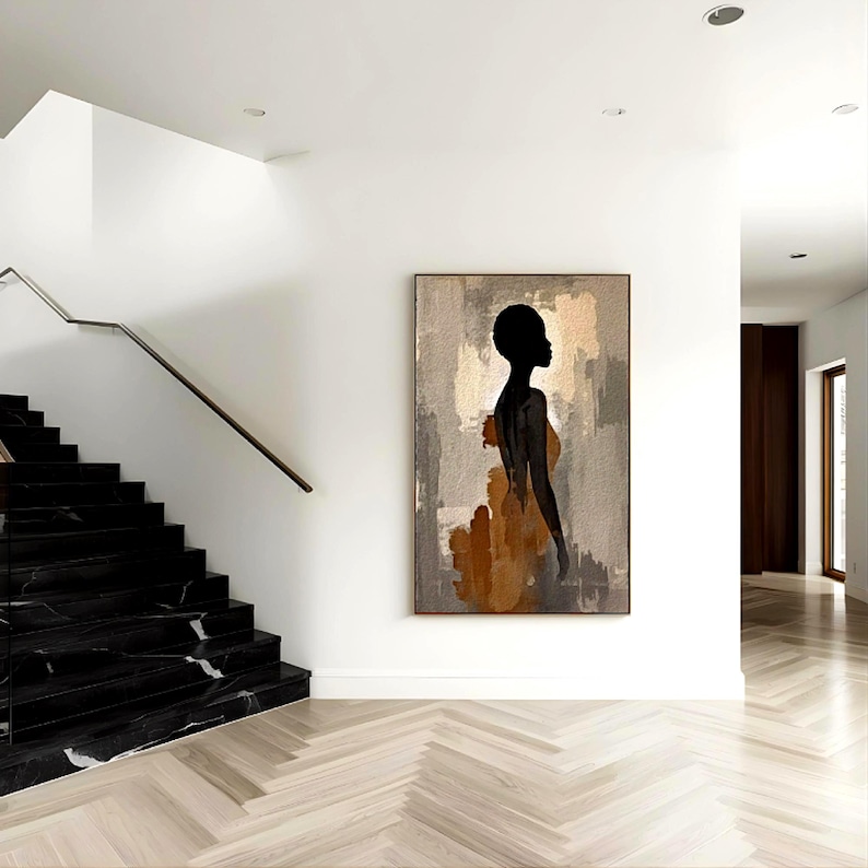 K&ouml;nnte beinhalten: Ein rechteckiges Wandbild mit der schwarzen Silhouette einer Person im Profil vor einem strukturierten Hintergrund aus grauen, beigen und braunen Pinselstrichen. Das Kunstwerk ist in einem d&uuml;nnen dunklen Rahmen gefasst und h&auml;ngt an einer wei&szlig;en Wand.