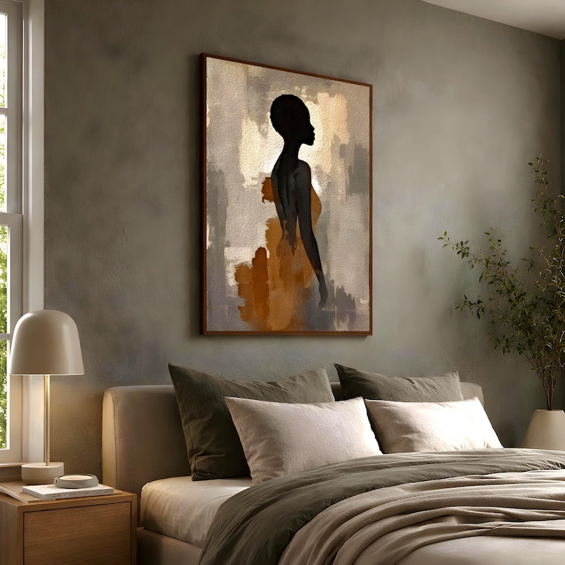 K&ouml;nnte beinhalten: Ein rechteckiger Wandkunstdruck mit der schwarzen Silhouette einer Person vor einem abstrakten Hintergrund aus strukturierten Gold-, Bronze- und Graut&ouml;nen. Das Kunstwerk ist mit einem d&uuml;nnen braunen Rahmen versehen.