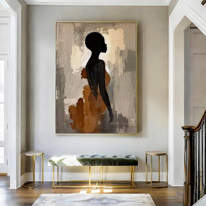K&ouml;nnte beinhalten: Ein rechteckiges Wandbild mit der schwarzen Silhouette einer Person im Profil vor einem strukturierten Hintergrund aus beigen, grauen und rostorangen Pinselstrichen. Das Kunstwerk ist in einem d&uuml;nnen goldenen Rahmen an einer hellgrauen Wand.