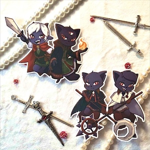 May include: A collection of fantasy-themed stickers featuring cartoon cat characters in various poses. One cat holds a sword, another a fireball. Also included are miniature silver swords and decorative red roses.