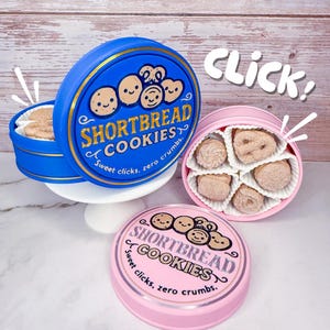 May include: A blue and pink tin of shortbread cookies with the text "SHORTBREAD COOKIES" and "Sweet clicks, zero crumbs." The blue tin is open, revealing cookies. The pink tin is closed. The word "CLICK!" is in the image.
