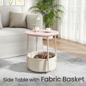 May include: A pink side table with a round top and a fabric basket. The table has a light pink metal frame and a beige fabric basket. The text "Side Table with Fabric Basket" is at the bottom of the image.