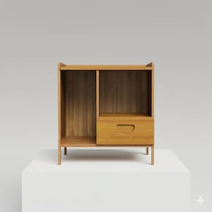 May include: A light brown wooden cabinet with a drawer and open shelving. The cabinet has a rectangular shape with a drawer featuring a curved handle. The open shelving is divided into two sections. The cabinet is elevated on thin legs.