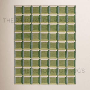 May include: Green and gray geometric patterned rug. The rug features a repeating 3D cube design in shades of green and gray, creating a textured appearance. The words "THE RENOVATION RUGS" are printed on the rug.