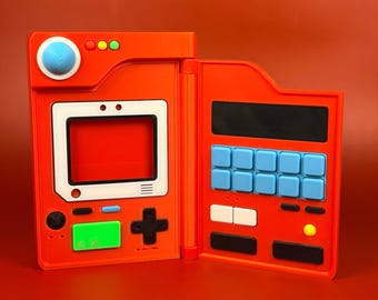 May include: An open, orange handheld gaming device with a white-framed screen and a black cross-shaped directional pad. It features blue, green, and yellow buttons, and a series of blue and white buttons on the right side. The device is set against a matching orange background.