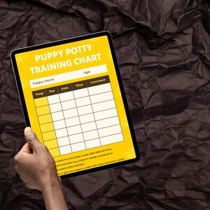 Könnte beinhalten: Ein digitales Tablet mit einem gelben "Welpen-Stubenreinheit-Trainingsplan" mit Abschnitten zur Aufzeichnung von Kot, Urin, Datum, Uhrzeit und Kommentaren. Das Tablet wird von einer Hand vor einem dunklen, strukturierten Hintergrund gehalten. Der Plan enthält den Text "Name des Welpen" und "Alter".