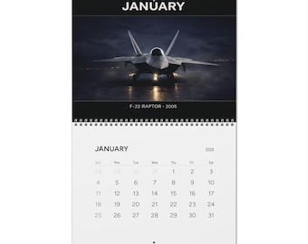 Può includere: Calendario a spirale con una fotografia di un jet F-22 Raptor. Il calendario mostra il mese di gennaio per l'anno 2026. L'immagine include il testo "JANUARY" e "F-22 RAPTOR 2005".