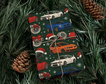 Könnte beinhalten: Dunkelgrünes Geschenkpapier mit Illustrationen von Autos, Turboladern, Weihnachtsmützen und Schneeflocken. Das Papier ist mit Bindfaden gebunden und vor einem Hintergrund aus Tannennadeln und Tannenzapfen platziert. Die Autos sind in verschiedenen Farben gehalten, darunter Rot, Weiß, Blau und Orange.