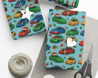 Könnte beinhalten: Geschenkpapier mit einem sich wiederholenden Muster von Cartoon-Autos in verschiedenen Farben, einige mit Weihnachtsmützen und Schleifen, auf hellblauem Hintergrund. Die verpackten Geschenke sind mit Bindfaden gebunden und mit dekorativen Anhängern verziert.