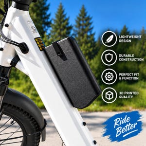 Peut inclure: Un boîtier de batterie rectangulaire noir monté sur le cadre blanc d'un vélo électrique. Le boîtier présente une surface texturée et un clip noir. Le texte à droite inclut LIGHTWEIGHT DESIGN, DURABLE CONSTRUCTION, PERFECT FIT & FUNCTION, 3D PRINTED QUALITY et RIDE BETTER.