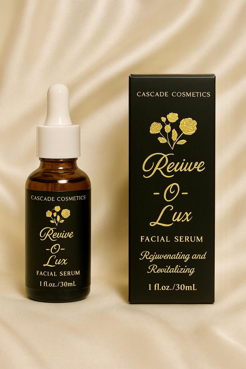 May include: A brown glass bottle and a black box of Cascade Cosmetics Revive -O- Lux Facial Serum. The bottle has a white dropper and gold text. The box has gold floral accents and text that reads "Rejuvenating and Revitalizing", 1 fl.oz./30mL.
