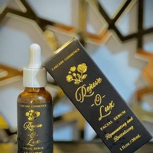 May include: A brown glass bottle with a white dropper and a black label with gold text that reads "Rejuve -O- Lux FACIAL SERUM 1 fl.oz./30mL". A black box with gold text reads "CASCADE COSMETICS Rejuve -O- Lux FACIAL SERUM Rejuvenating and Revitalizing 1 fl.oz./30mL".