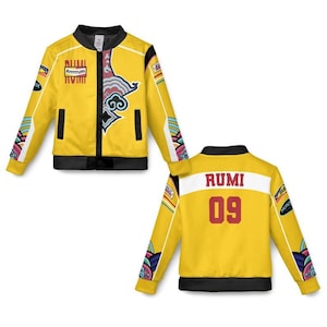 May include: Yellow bomber jacket with black trim and colorful accents. The front features a decorative design and the text "Rrrrrrum". The back displays "RUMI" and the number "09" in red.