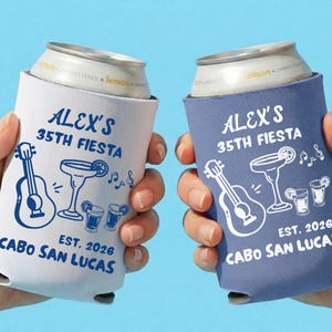 May include: Two drinks can coolers, one white and one blue, each printed with "ALEX'S 35TH FIESTA" and graphics of a guitar, margarita, and musical notes. The text "EST. 2026 CABO SAN LUCAS" is also visible.