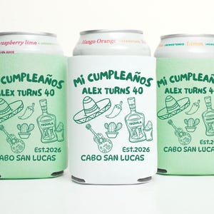 May include: Three drinks can coolers with a Mexican theme. The coolers are light green and white, with the text "Mi Cumpleaños Alex Turns 40" and illustrations of a sombrero, tequila bottle, and guitar. The text "Cabo San Lucas" is also included.