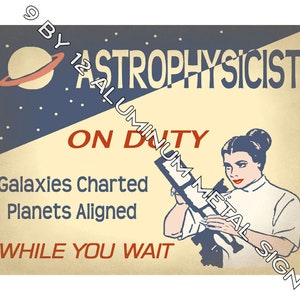 May include: A vintage-style metal sign with a yellow background and blue and red accents. The sign features a cartoon image of a woman looking through a telescope with the text "ASTROPHYSICIST ON DUTY Galaxies Charted Planets Aligned WHILE YOU WAIT" and "BY 12 ALUMINUM METAL SIGN".