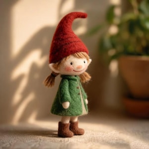 May include: A handmade felt doll of a gnome wearing a tall, red hat and a green coat. The doll has a smiling face, brown boots, and small pigtails. The doll is standing on a textured surface.