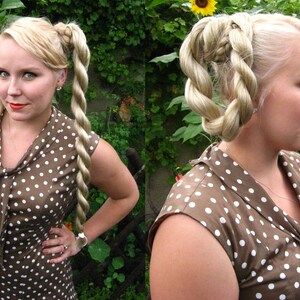 May include: A woman with blonde hair styled in two braided rope twists, wearing a brown dress with white polka dots.