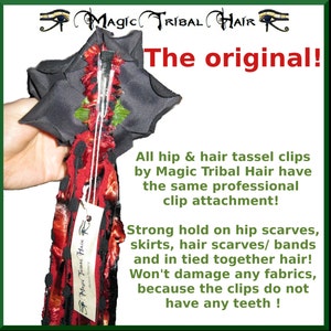 K&ouml;nnte beinhalten: Ein roter, schwarzer und gr&uuml;ner Quasten-Haarclip mit einer schwarzen Stoffbasis und einem Metallclip. Der Clip ist so konzipiert, dass er Schals, Haarb&auml;nder und gebundenes Haar h&auml;lt. Der Text "Magic Tribal Hair" ist auf einem am Clip befestigten Etikett aufgedruckt. Der Text "The original!" ist in roten Buchstaben auf wei&szlig;em Hintergrund aufgedruckt. Der Text "All hip & hair tassel clips by Magic Tribal Hair have the same professional clip attachment! Strong hold on hip scarves, skirts, hair scarves/ bands and in tied together hair! Won't damage any fabrics, because the clips do not have any teeth!" ist unter dem Bild aufgedruckt.