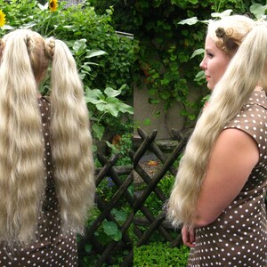 May include: A woman with long, wavy, blonde hair styled in two pigtails. She is wearing a brown and white polka dot dress.