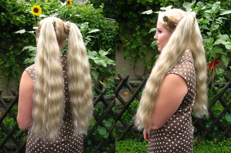 May include: A woman with long, wavy, blonde hair styled in two pigtails. She is wearing a brown and white polka dot dress.