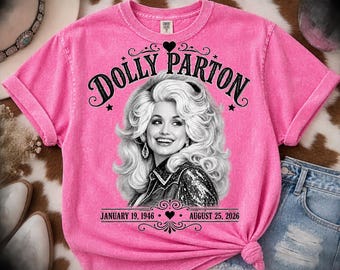 Könnte beinhalten: Ein leuchtend rosa T-Shirt mit kurzen Ärmeln und einer schwarz-weißen Grafik von Dolly Parton mit voluminösem Haar. Der Text lautet DOLLY PARTON oben und JANUARY 19, 1946 - AUGUST 25, 2026 unten, verziert mit dekorativen Herz-Elementen.