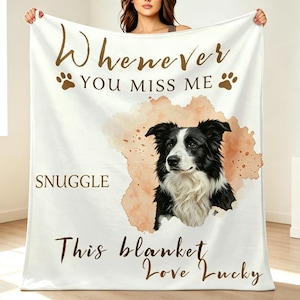 May include: A white fleece blanket featuring a black and white border collie portrait centred on a soft peach watercolour splash. The text reads: Whenever you miss me snuggle this blanket love Lucky, accented by two brown paw prints.