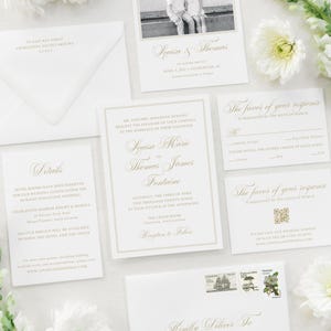 May include: Elegant wedding invitation suite with gold script on white cards. Includes a "Save the Date" card with a photo, invitation, RSVP cards, and an envelope. Floral accents and a stamp add to the refined aesthetic.