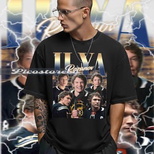Könnte beinhalten: Schwarzes T-Shirt mit einem goldenen "Ilya Rozanov"-Design und einer Collage von Bildern. Das Shirt hat einen Vintage-Look mit verblasstem Hintergrund und Blitzgrafiken. Das Model trägt eine Brille und eine silberne Kette.