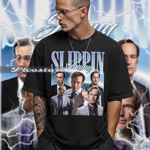 Peut inclure: T-shirt noir avec un graphisme du personnage Saul Goodman de la série télévisée "Better Call Saul". Le design comprend le texte "Slippin' Jimmy" dans une police stylisée, ainsi que des images du personnage. Fond bleu avec effet d'éclairs.