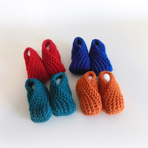 May include: Six pairs of crocheted baby booties in teal, orange, and red.