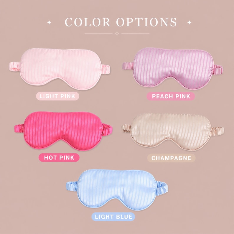 May include: Five sleep masks with elastic headbands arranged in a grid, labeled COLOR OPTIONS. The masks are light pink, peach pink, hot pink, champagne, and light blue. Each mask features a subtle vertical striped pattern and a smooth finish.