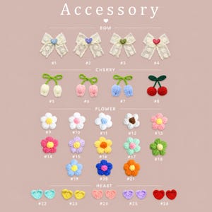 May include: A collection of crochet accessories labeled Accessory, Bow, Cherry, Flower, and Heart. Items include lace bows with small hearts, pairs of cherries in various colors, multi-colored crochet flowers, and pairs of small crochet hearts.