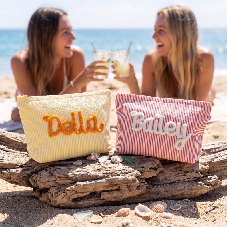 May include: Two rectangular zippered pouches made of seersucker fabric. The yellow pouch features the name Della in orange yarn lettering, while the red and white striped pouch features the name Bailey in white yarn lettering on the front.