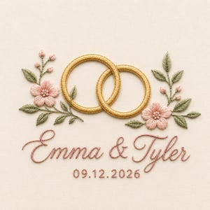 Puede incluir: Un diseño de bordado que presenta dos anillos dorados entrelazados centrados entre dos ramas florales con flores rosas y hojas verdes. Debajo de los anillos, el texto dice Emma & Tyler en letra cursiva, seguido de la fecha 09.12.2026 en una fuente sencilla.