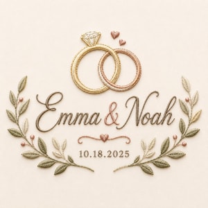 Könnte beinhalten: Ein Stickmotiv mit zwei ineinander verschlungenen Ringen in Gold und Roségold, den Namen Emma & Noah in brauner Schreibschrift, einem kleinen Herz und dem Datum 18.10.2025, umrahmt von zwei symmetrischen Olivenzweigen mit grünen und beigen Blättern.