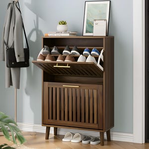 May include: A dark brown wooden shoe storage cabinet with a flip-down top and a lower cabinet door. The top section is open, displaying several pairs of shoes. The cabinet has gold-colored handles and is set against a light blue wall.