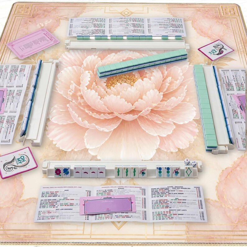 May include: A complete Mahjong set with white and teal tiles, dice, and instruction cards. The set is arranged on a floral-patterned mat with a large pink peony in the center. The tiles are arranged in racks, ready for play.