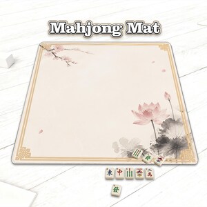 May include: A beige Mahjong mat with a gold border and floral design. The mat features a pink lotus flower and cherry blossoms. Several Mahjong tiles are placed on the mat, with the text "Mahjong Mat" at the top.
