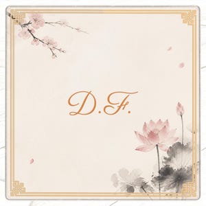 May include: A square card with a cream background, featuring a gold border and floral illustrations. The design includes a lotus flower, cherry blossoms, and the initials "D.F." in a copper-colored script. The overall aesthetic is delicate and artistic.