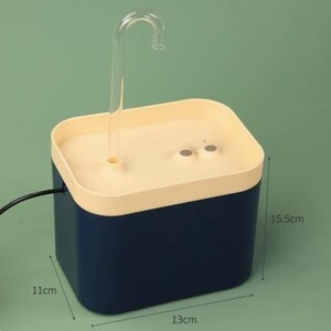 May include: A blue and cream-colored pet water fountain. The fountain has a clear, curved spout and measures approximately 5.1 inches tall, 4.3 inches wide, and 6.1 inches long.