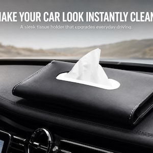 Puede incluir: Un soporte rectangular negro para pañuelos de coche con costuras blancas y una abertura ovalada blanca central, de la que sobresale un pañuelo blanco. El texto "MAKE YOUR CAR LOOK INSTANTLY CLEANER" y "A sleek tissue holder that upgrades everyday driving" es visible.