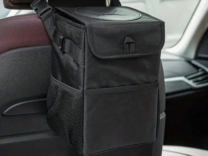 Peut inclure: Sac poubelle de voiture noir avec couvercle et sangle r&eacute;glable. Le sac a une poche en filet et une fermeture &agrave; rabat. Con&ccedil;u pour &ecirc;tre suspendu &agrave; l'appuie-t&ecirc;te de la voiture. Fabriqu&eacute; en mat&eacute;riau durable et r&eacute;sistant &agrave; l'eau.