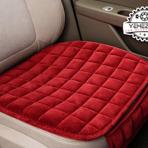Könnte beinhalten: Ein rotes, gestepptes Autositzkissen. Das Kissen hat ein Rautenmuster und liegt auf einem beigen Autositz. Das Bild zeigt auch ein Logo mit der Aufschrift "YEHEZKEL CAR ACCESSORIES". Das Kissen ist quadratisch mit abgerundeten Ecken.