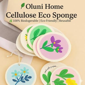 May include: A stack of round cellulose eco sponges with floral designs in pink, green, and blue. The sponges are on a white plate. The text "Oluni Home Cellulose Eco Sponge" is at the top.