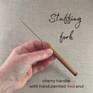 May include: A stuffing fork with a long, thin metal shaft and a smooth cherry wood handle. The end of the handle features a hand-painted red accent. The text "Stuffing fork" and "cherry handle with hand painted Red end" are visible in the image.
