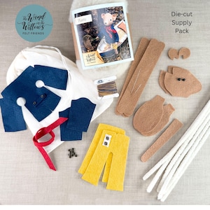 May include: A craft kit for a felt Ratty character including die-cut tan felt body pieces, blue felt clothing, yellow felt trousers, a red ribbon, white pipe cleaners, brown thread, small black beads, and an instruction booklet labeled Ratty.