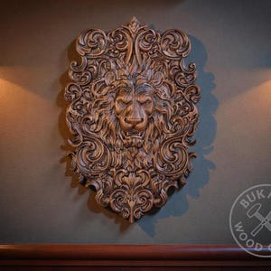 a large, intricately carved lion head mounted on a wall, with two lights on either side of it.