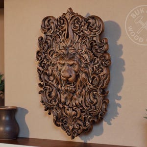 a large, intricately carved wooden lion head mounted on a wall, surrounded by various decorative elements such as vases and potted plants.